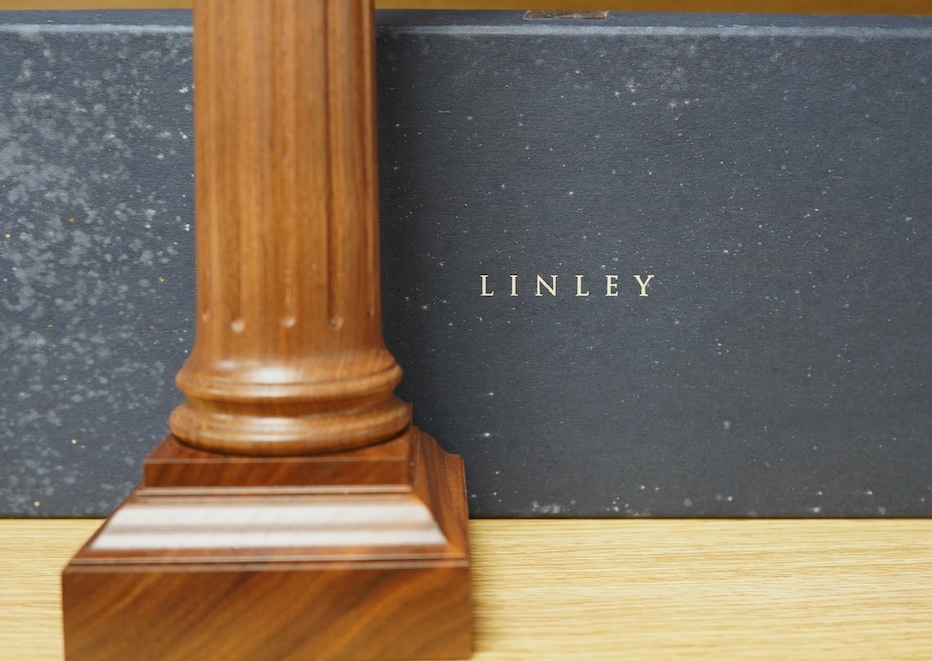 A pair of David Linley walnut candlesticks in the form of fluted columns, 30cm high, with the original card box. Condition - some notable water damage to the box, otherwise good.